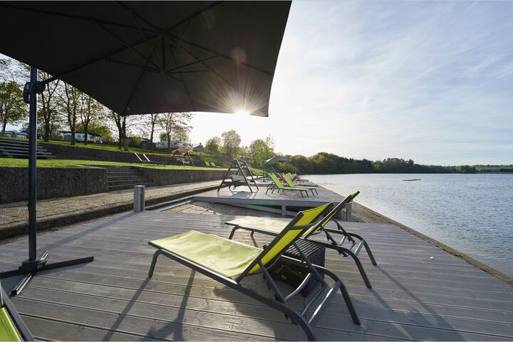 Chaises longues sur le ponton en bois au bord du lac