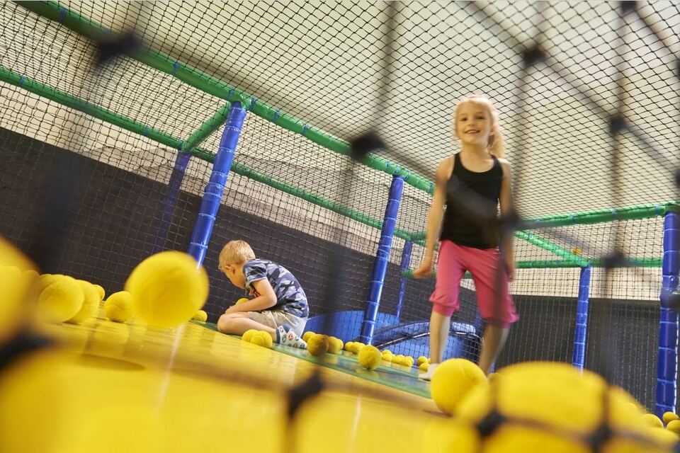 Des enfants jouent dans l’aire de jeux avec des balles jaunes